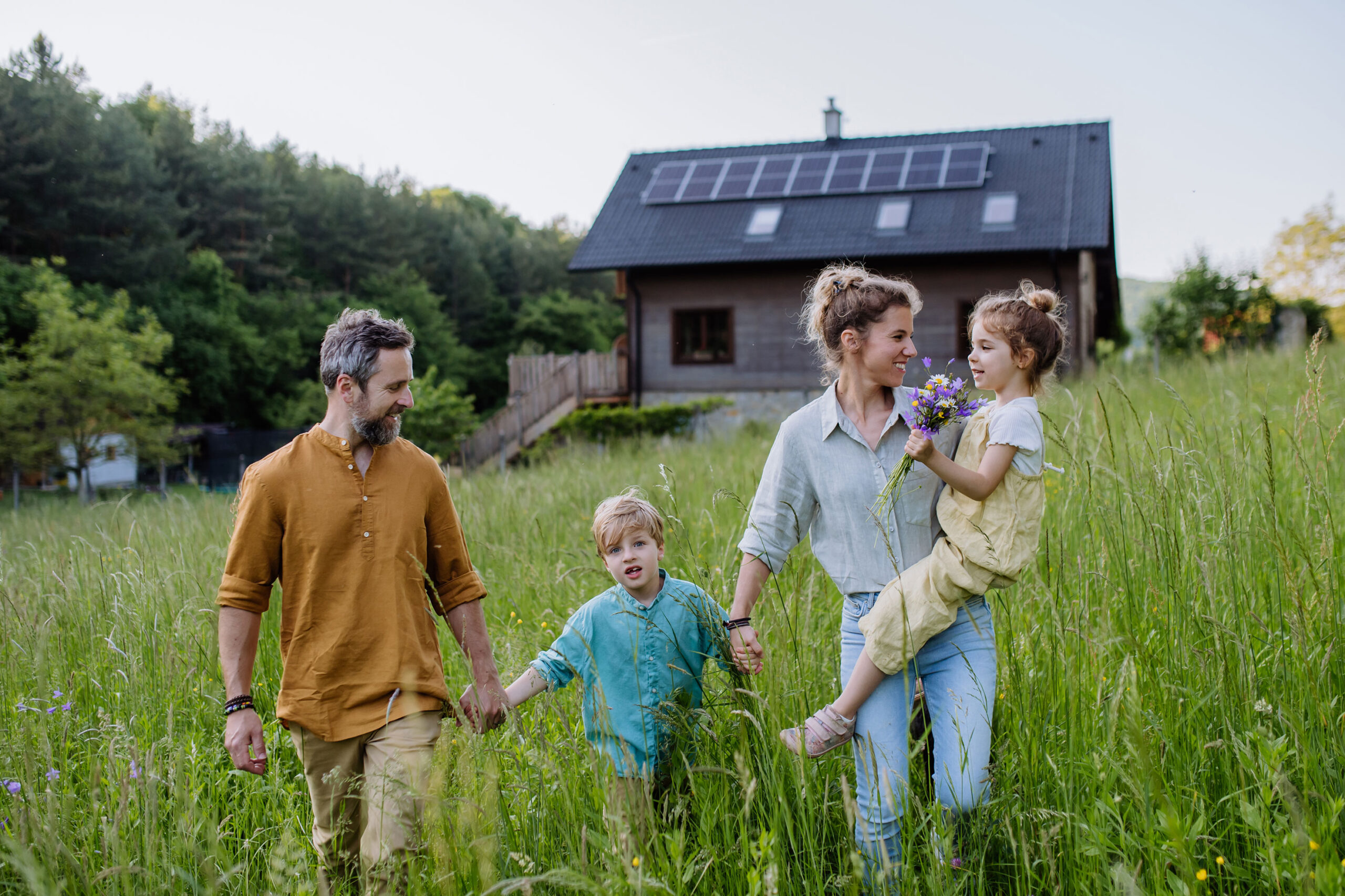 Familie vor Eigenheim mit Solarthermie auf dem Dach